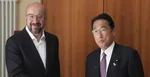 Predseda Európskej rady Charles Michel (vľavo) si podáva ruku s japonským premiérom Fumiom Kišidom.