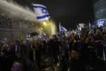 Izraelskí policajti zasahujú vodným delom na rozohnanie izraelských demonštrantov, ktorí blokujú diaľnicu počas protestu proti vládnemu návrhu súdnej reformy izraelského premiéra Benjamina Netanjahua v Tel Avive 25. marca 2023.