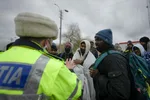Policajt sa zhovára s utečencami v rumunskom meste Siret pri hranici s Ukrajinou v pondelok 28. februára 2022.