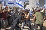 Izraelský policajt sa bije s demonštrantmi, ktorí sa pokúšajú blokovať hlavnú cestu počas protestu proti vládnemu návrhu súdnej reformy nového premiéra Benjamina Netanjahua v Tel Avive.