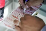 Muž vypĺňa tiket americkej lotérie Mega Millions v kalifornskom Palo Alto v piatok 29. júla 2022.