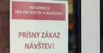 Šaca informuje návštevníkov nemocnice o zákaze návštev vylepeným oznamom pri hlavnom vchode.