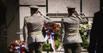 Vojaci pred pamätníkom obetí v obci Kalište, ktorú vypálili nacisti.