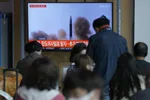 Ľudia sledujú televízne správy o odpálení neidentifikovaného projektilu zo strany Severnej Kórey na železničnej stanici v Soule v stredu 4. mája 2022.