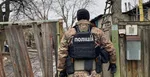 Na archívnej snímke ukrajinský policajt v Charkovskej oblasti dokumentuje následky ostreľovania