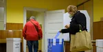 volička vhadzuje obálku s hlasovacími lístkami do volebnej schránky pre voľby do VÚC