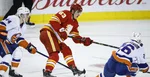 Na snímke uprostred slovenský center Calgary Adam Ružička medzi hráčmi Islanders