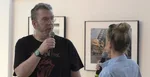 Richarda Müllera na výstave jeho fotografií, spovedá moderátorka Adela Vinczeová.