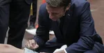 Emmanuel Macron sa podpisuje chlapcovi na jeho sadru pred príchodom do volebnej miestnosti v obci Le Touquet.
