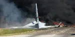 Pohľad na dym a plamene zo spadnutého nákladného lietadla typu C-130.