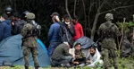 Migranti sedia po prekročení hranice z Bieloruska do Poľska v poľskej dedine Usnarz Gorny.