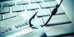 Bankomatová karta na klávesnici zaseknutá rybárskym háčikom.