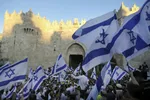 zraelskí nacionalisti mávajú izraelskými vlajkami počas vlajkového pochodu v Jeruzaleme