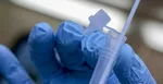 Zdravotnícky pracovník drží súpravu na rýchly test na prítomnosť COVID-19