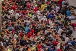 Maloletí migranti bez sprievodu sedia pred skladom používaným ako dočasný prístrešok v španielskej enkláve Ceuta.