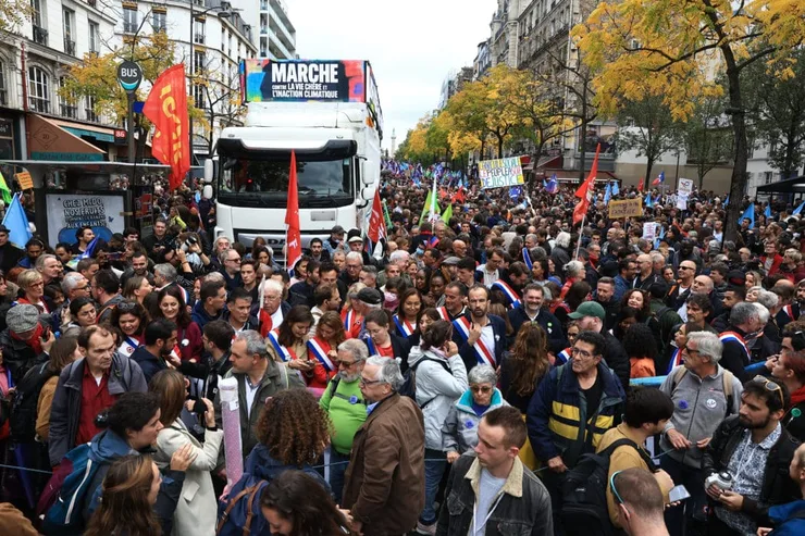 ľudia sa zhromaždili na proteste proti rastúcim životným nákladom a nedostatočnému úsiliu v boji proti klimatickej zmene v Paríži 16. októbra 2022.